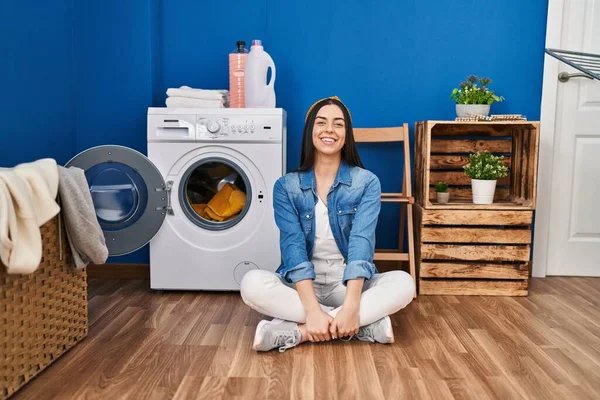 Hispanic Kvinna Gör Tvätt Sitter Golvet Ser Positiv Och Glad — Stockfoto