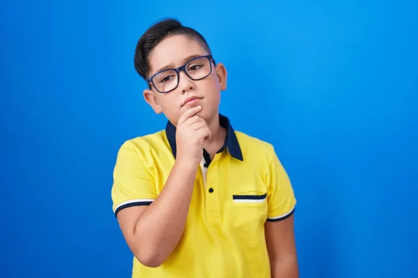 Joven Niño Hispano Pie Sobre Fondo Azul Cara Seria Pensando — Foto de Stock