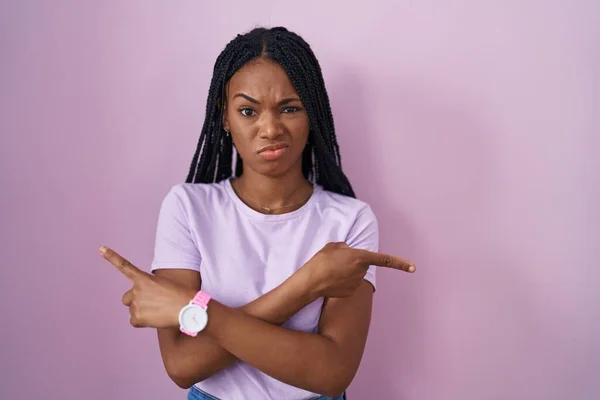 African American Woman Braids Standing Pink Background Pointing Both Sides — Stockfoto