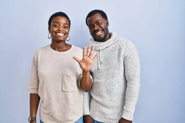 Jong Afrikaans Amerikaans Paar Staande Blauwe Achtergrond Samen Tonen Wijzen — Stockfoto