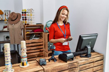 Kafkasyalı genç bir esnaf dükkanında elinde dolarlarla mutlu bir şekilde gülümsüyor..