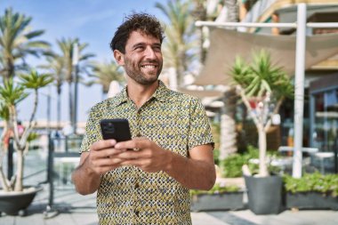 Sokakta akıllı telefon kullanan, kendine güvenen genç bir İspanyol.