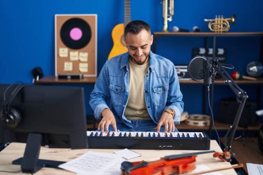 Genç İspanyol müzisyen müzik stüdyosunda piyano çalıyor.