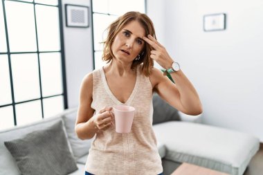 Orta yaşlı bir kadın evde kahve içerek kendini vuruyor ve öldürüyor. Elini ve parmaklarını silah gibi kullanıyor. İntihar jesti.. 