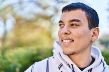 Parkta kendinden emin bir şekilde duran genç adam.