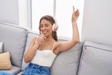 Genç, güzel, İspanyol bir kadın evde şarkı söylüyor.