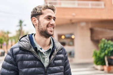 Young man smiling confident looking to the side at street