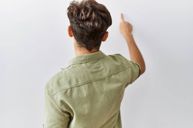 Young arab doctor man standing over isolated background posing backwards pointing ahead with finger hand 