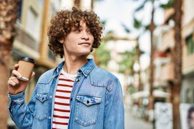 Genç İspanyol adam şehirde bir fincan kahve içiyor.