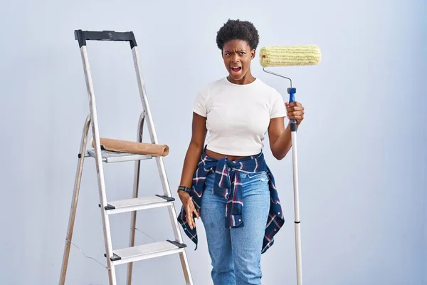 Mulher Afro Americana Segurando Pintor Rolos Irritado Louco Gritando Frustrado — Fotografia de Stock