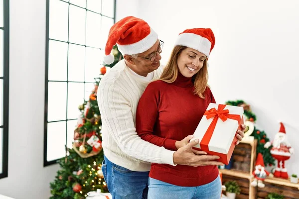 Középkorú Spanyol Pár Mosolyog Boldog Ölelés Gazdaság Karácsonyi Ajándék Otthon — Stock Fotó