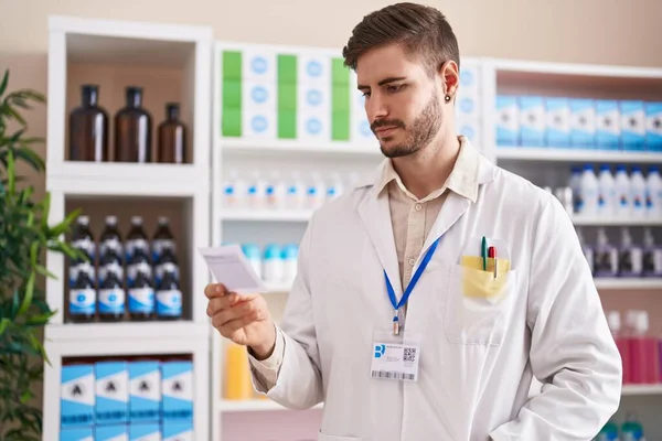 Young Caucasian Man Pharmacist Reading Prescription Pharmacy — Zdjęcie stockowe