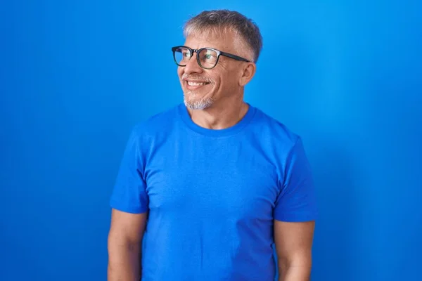 Hombre Hispano Con Pelo Gris Pie Sobre Fondo Azul Mirando —  Fotos de Stock