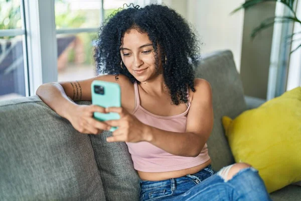 Mujer Hispana Joven Usando Teléfono Inteligente Sentado Sofá Casa —  Fotos de Stock