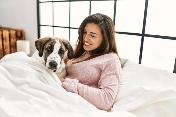 Junge Frau Lächelt Selbstbewusst Und Umarmt Hund Der Auf Bett — Stockfoto