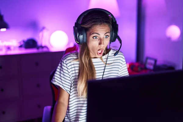 若いですブロンド女性再生ビデオゲーム恐怖と驚きのために口を開けて 不信顔 — ストック写真