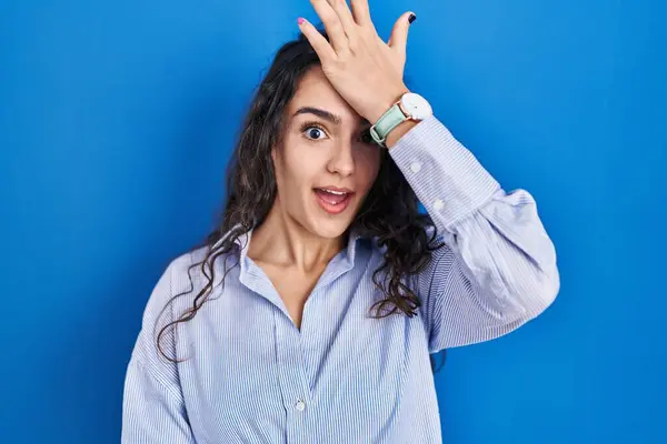 Jovem Morena Sobre Fundo Azul Surpreso Com Mão Cabeça Por — Fotografia de Stock