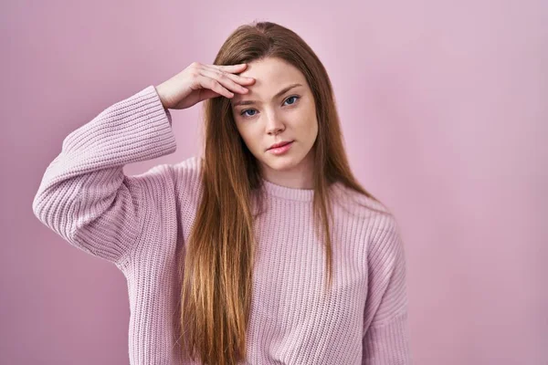 ピンクの背景の上に立つ若い白人女性は 額に手で問題を心配し 強調し 危機への緊張と不安 — ストック写真