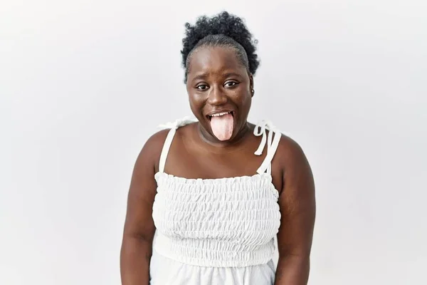 年轻的非洲女人站在白色孤立的背景上 带着滑稽的表情伸出舌头 高兴极了 情感概念 — 图库照片