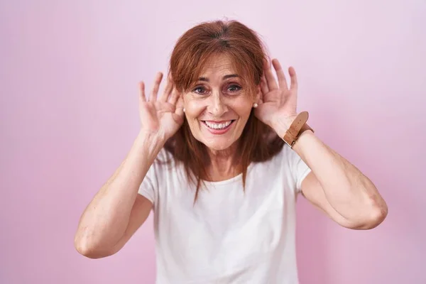 Middle Age Woman Standing Pink Background Trying Hear Both Hands — Stock fotografie