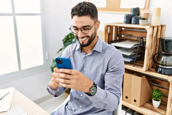 Νεαρός Άραβας Χαμογελά Αυτοπεποίθηση Χρησιμοποιώντας Smartphone Που Εργάζονται Στο Γραφείο — Φωτογραφία Αρχείου