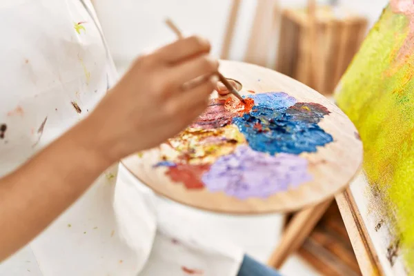 年轻的拉丁女子在艺术工作室的调色板上混合着色彩 — 图库照片