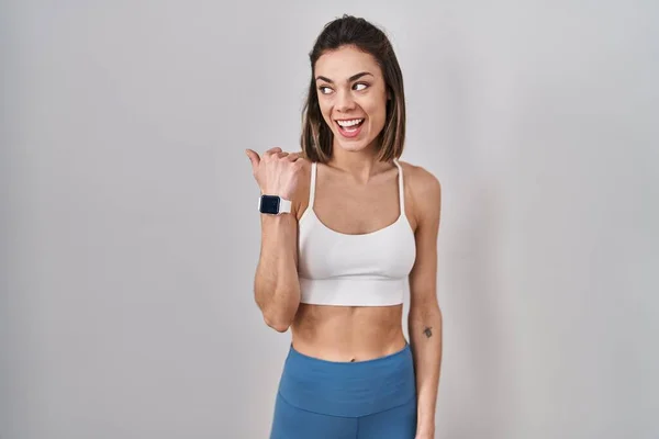 Zole Edilmiş Arka Planda Spor Giyinen Spanyol Kadın Gülümsüyor Başparmağıyla — Stok fotoğraf