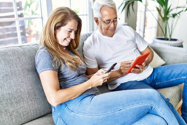 Middle Age Hispanic Couple Smiling Happy Using Tablet Smartphone Home — Φωτογραφία Αρχείου