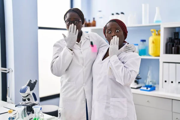 科学研究所で働いている2人のアフリカ人女性が手で口を覆い ショックを受け 間違いを恐れている 驚きの表情 — ストック写真