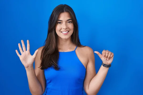 Mujer Hispana Pie Sobre Fondo Azul Mostrando Señalando Hacia Arriba — Foto de Stock