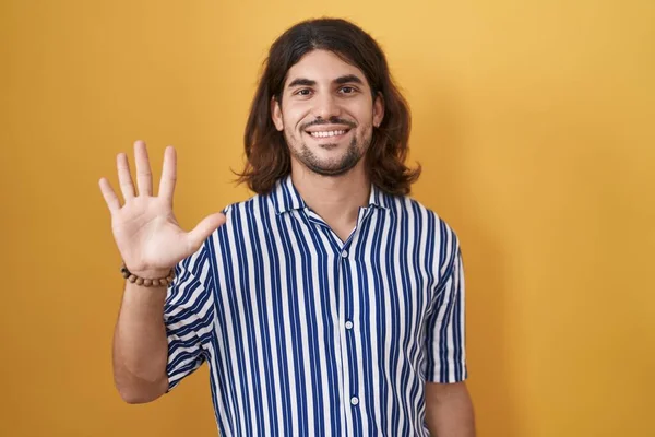 Латиноамериканец Длинными Волосами Стоит Желтом Фоне Показывает Пальцами Номер Пять — стоковое фото