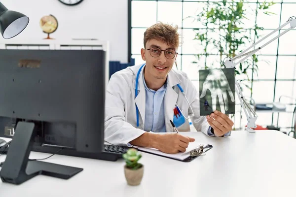 Young Caucasian Man Wearing Doctor Uniform Holding Xray Clinic — Stok fotoğraf