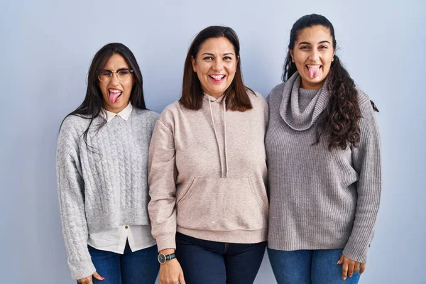 Mother Two Daughters Standing Blue Background Sticking Tongue Out Happy — Stockfoto