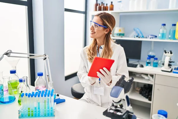 实验室里穿着科学家制服的金发女青年用笔记本电脑 — 图库照片