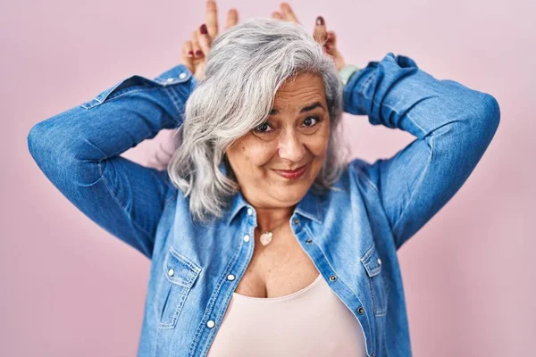 Kobieta Średnim Wieku Siwymi Włosami Stojąca Różowym Tle Pozująca Zabawnie — Zdjęcie stockowe