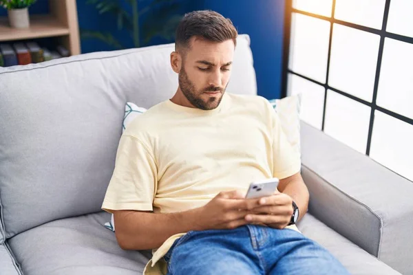 Jovem Hispânico Usando Smartphone Sentado Sofá Casa — Fotografia de Stock