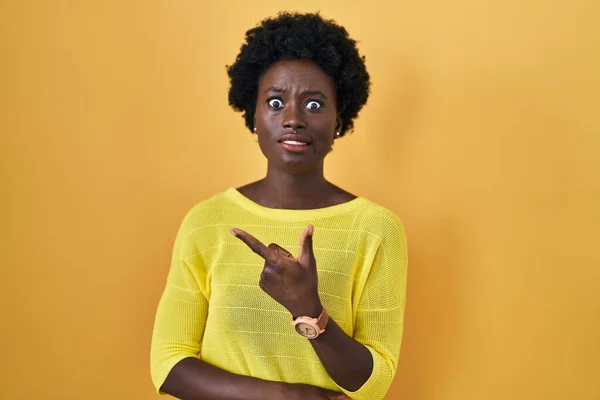 African Young Woman Standing Yellow Studio Pointing Aside Worried Nervous — Zdjęcie stockowe