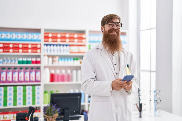 Jovem Farmacêutico Ruivo Usando Smartphone Trabalhando Farmácia — Fotografia de Stock