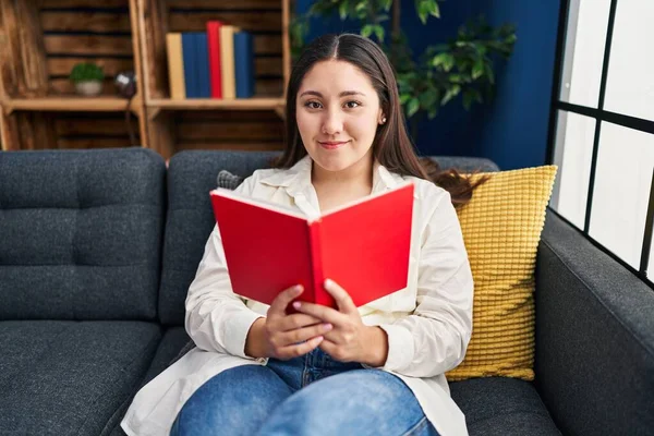 Young Hispanic Woman Reading Book Sitting Sofa Home — Stock Photo, Image