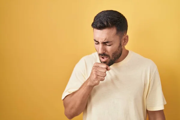 Hombre Hispano Guapo Parado Sobre Fondo Amarillo Sintiéndose Mal Tosiendo — Foto de Stock