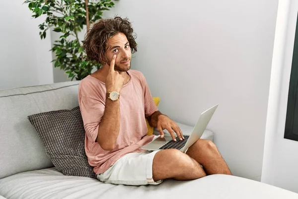 Evdeki Kanepede Oturan Genç Spanyol Adam Dizüstü Bilgisayarını Kullanarak Gözüne — Stok fotoğraf