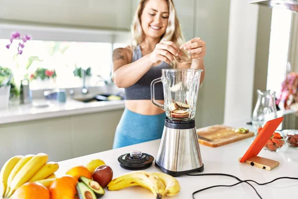 Young Woman Looking Online Juice Recipe Pouring Apple Blender Kitchen — Stok fotoğraf