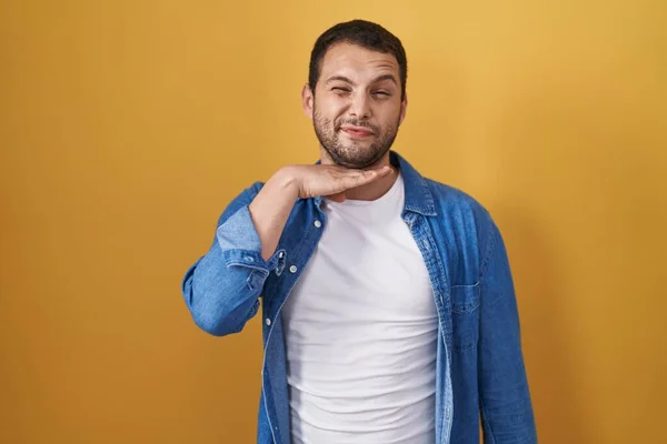 Hispanic Man Standing Yellow Background Cutting Throat Hand Knife Threaten — Stockfoto