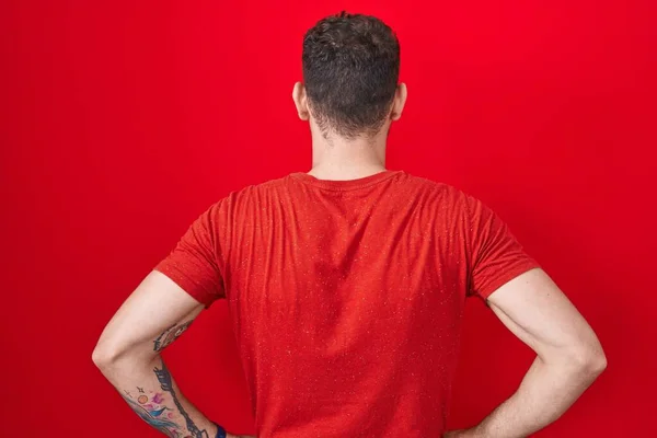 Genç Spanyol Bir Adam Kırmızı Arka Planda Dikiliyor Arkaya Bakıyor — Stok fotoğraf