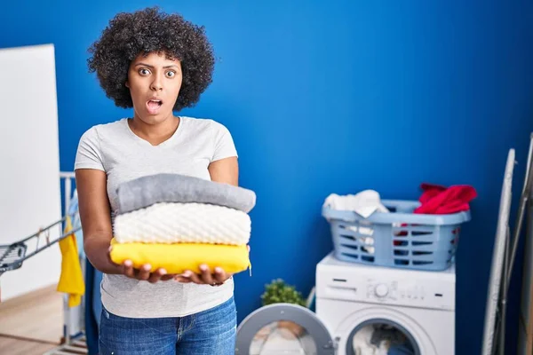 Black Woman Curly Hair Holding Clean Laundry Shock Face Looking — ストック写真