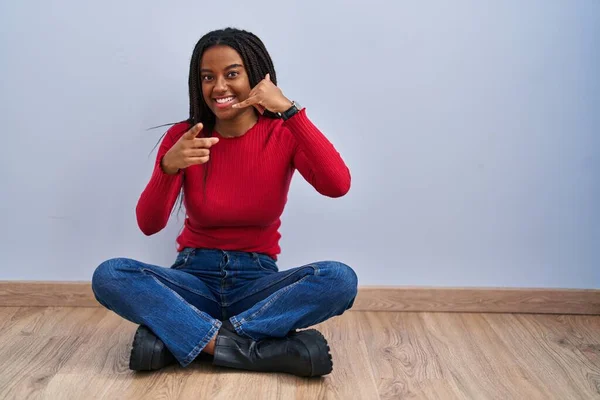 Joven Afroamericano Con Trenzas Sentado Suelo Casa Sonriendo Haciendo Hablar —  Fotos de Stock