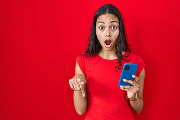 Jeune Femme Brésilienne Utilisant Smartphone Sur Fond Rouge Pointant Vers — Photo
