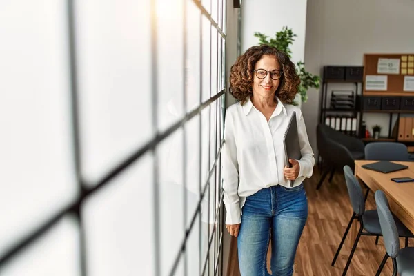 Mujer Hispana Mediana Edad Sonriendo Confiada Sosteniendo Portapapeles Oficina —  Fotos de Stock