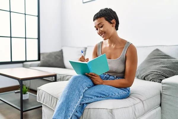 Joven Mujer Hispana Sonriendo Confiada Escritura Cuaderno Casa —  Fotos de Stock