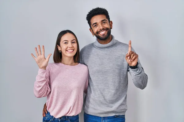 Young Hispanic Couple Standing Together Showing Pointing Fingers Number Six — Fotografia de Stock